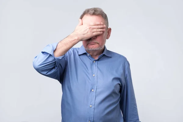 Ein älterer Mann verdeckt seine Augen. Er ist verärgert — Stockfoto