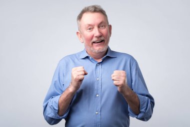 Komuta sizde kadar yumruk yükselterek ve gülümseyen mavi gömlekli