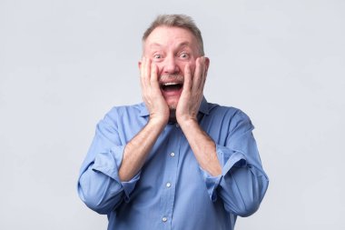 adam ağız geniş açık, koymak eller yanaklarda tutmak.