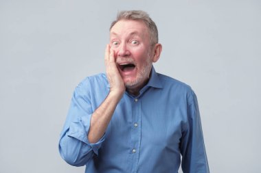 adam ağız geniş açık, koymak eller yanaklarda tutmak.