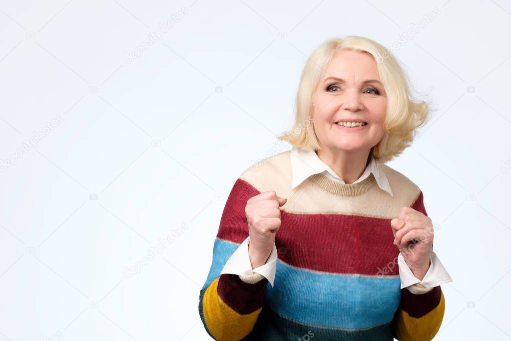 senior blonde woman rejoicing at positive news