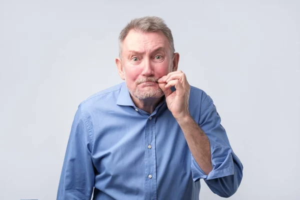 Senior man i blå skjorta gör tystnad gest — Stockfoto