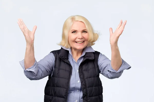 Старша жінка піднімає руки на позитивні почуття — стокове фото