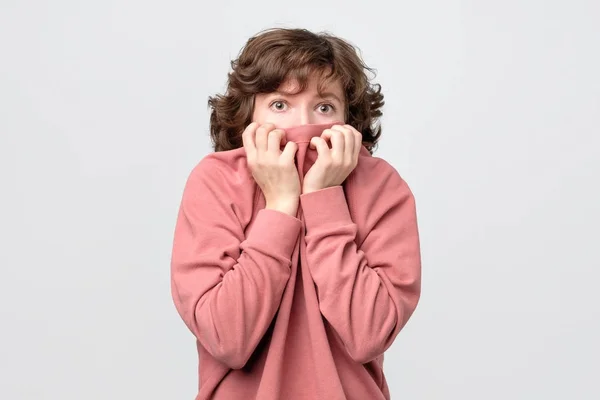 Кудрявая женщина грызет ногти, жаждущая чего-то или тревожась — стоковое фото