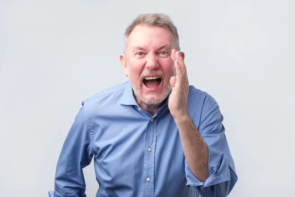 Líder sênior homem de camisa azul gritando . — Fotografia de Stock