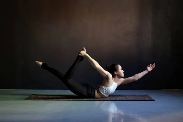 Jonge aantrekkelijke vrouw het beoefenen van yoga, stretching in Salabhasana pose — Stockfoto