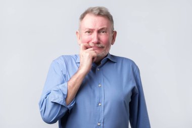 Kıdemli adam suçlu bir özür ifadesi ile bakıyor