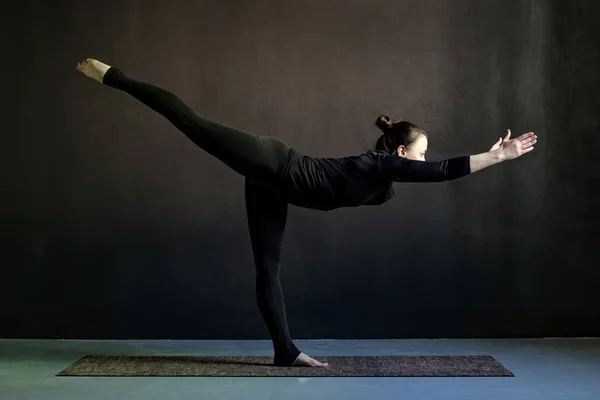 Slanke jonge vrouw beoefenen van yoga, staande in Warrior houding of Virabhadrasana — Stockfoto