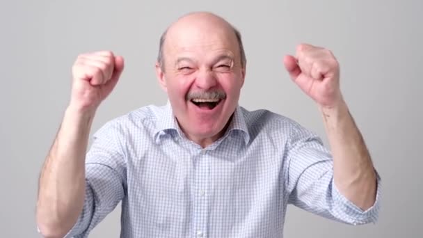 Mature hispanic man is happy with his win. He is holding his fists and shout Wow — Stock Video