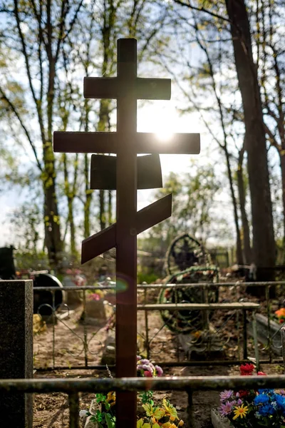 Grave cross on the Orthodox Christian cemetery at sunny day.