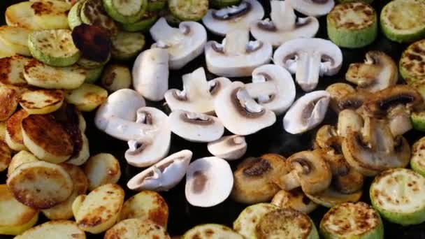Чоловік готує смажені овочі та гриби на сковороді — стокове відео