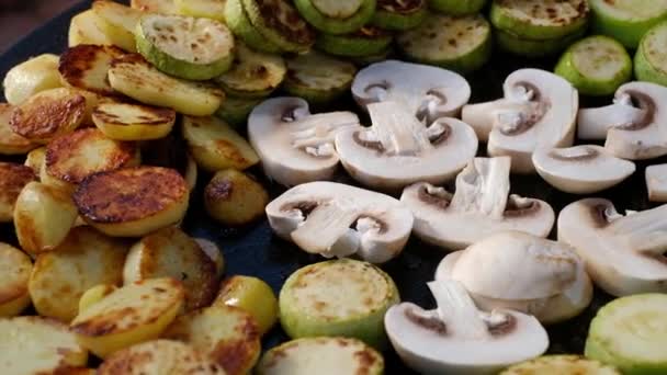 Чоловік готує смажені овочі та гриби на сковороді — стокове відео