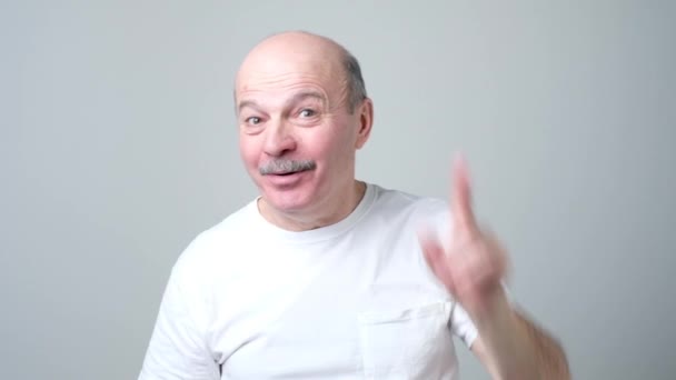 Tevreden volwassen man toont wijsvinger omhoog, geven advies — Stockvideo