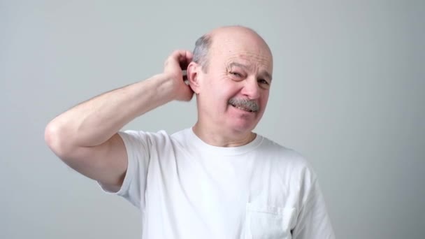 Starszy mężczyzna zarysowania głowy i zastanawiał się pytanie — Wideo stockowe