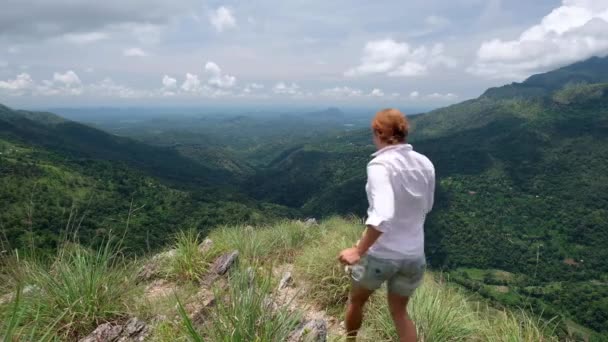 Young female traveler is going at the edge the mini Adams peak — Stock Video