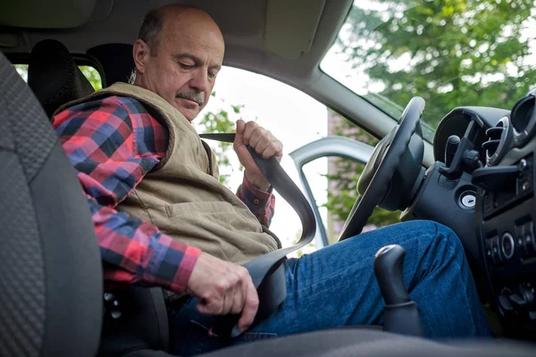 Hombre maduro abrochando el cinturón de seguridad en coche — Foto de Stock