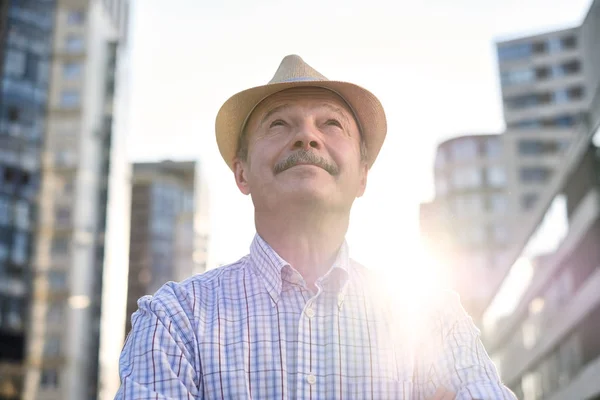 Homem de chapéu hispânico com bigode olhando para a câmera sorrindo na cidade — Fotografia de Stock