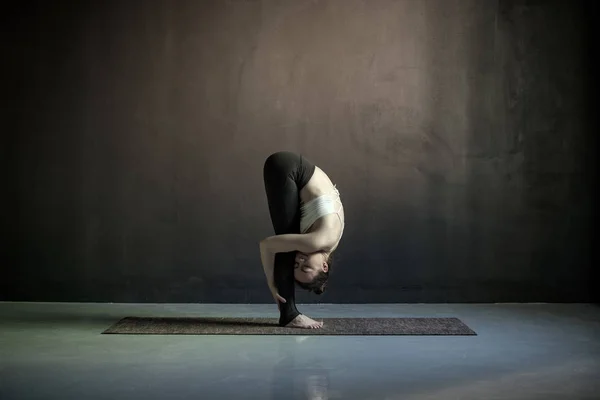 Vrouw het beoefenen van yoga, het doen van hoofd tot knieën, uttanasana oefening — Stockfoto