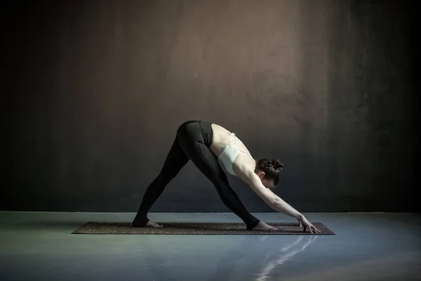 Vrouw in brede benen voorwaarts buigen oefening, Prasarita Padottanasana pose — Stockfoto