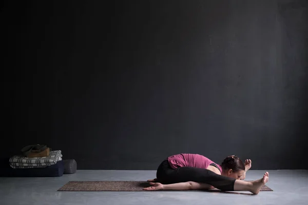 Молодая женщина практикует йогу, делает Курмасану, Черепашью осанку, Черепашью позу — стоковое фото