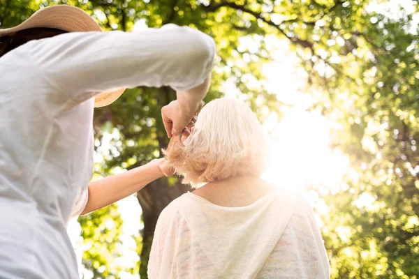 Mujer haciendo un corte de pelo a su abuela — Foto de Stock