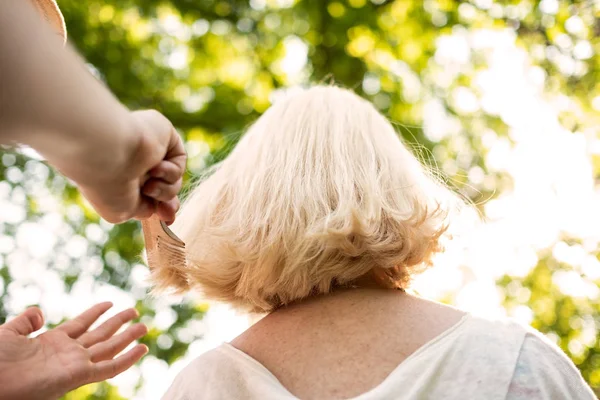 Mujer haciendo un corte de pelo a su abuela — Foto de Stock