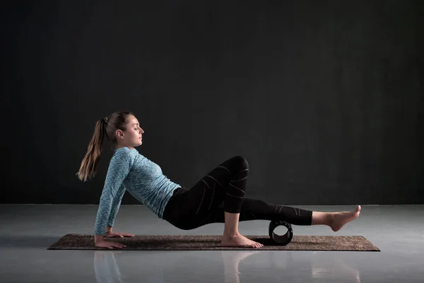 Vrouw maakt gebruik van schuim roller om pijn te verwijderen, rekken en massage spieren van benen. — Stockfoto