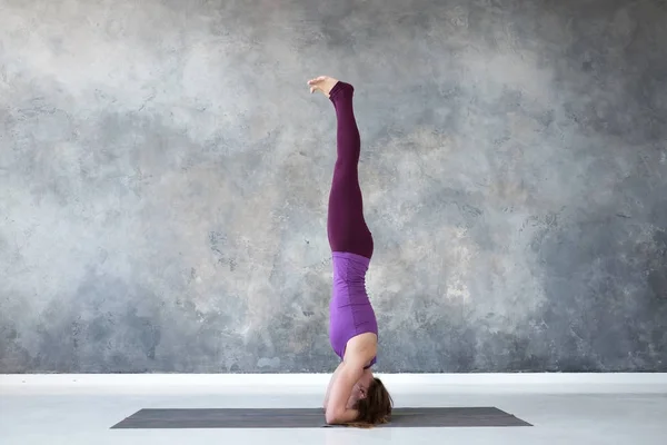 Vrouw beoefenen van yoga, staande in salamba Sirsasana oefening, shirshasana pose — Stockfoto