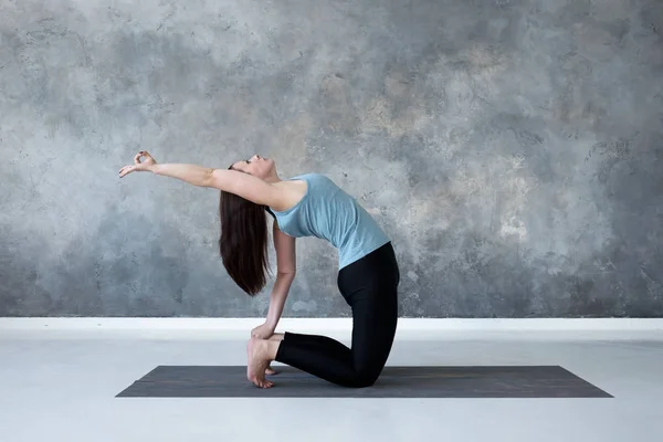 Kvinna som tränar yoga, gör Ushtrasana, kamel pose, på Studio Full längd. — Stockfoto