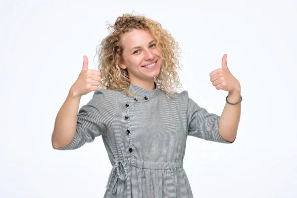 Sonriendo bastante rizado joven mujer mostrando pulgares hacia arriba ser feliz de recibir un trabajo . —  Fotos de Stock