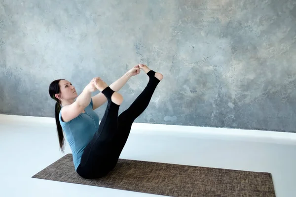 Young woman practicing yoga, doing wide legged boat exercise, Prasarita Navasana — Stock Photo, Image