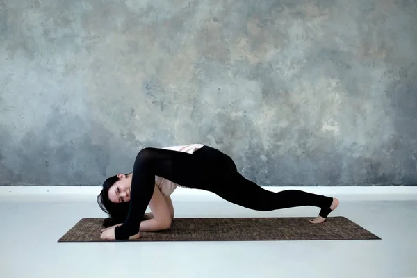 Full length profile view of woman stretching in leg lunge position. — Stock Photo, Image