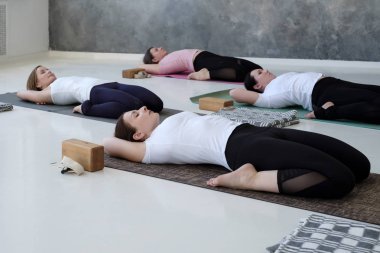 genç kadınlar yoga egzersiz yapıyor, Yatan Hero poz yalan, Supta Virasana