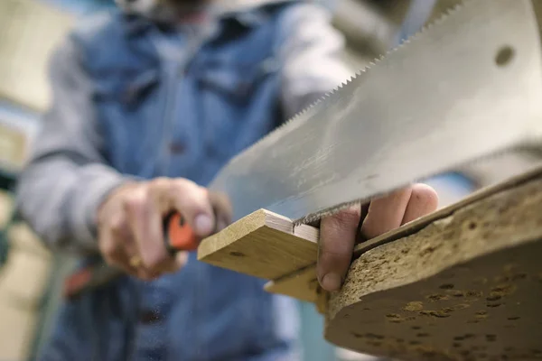 Aserrar un tablero de madera con sierra de mano japonesa especial o sierra de hackear durante la carpintería — Foto de Stock
