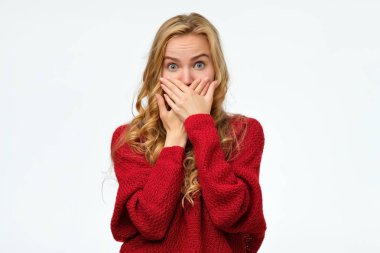 elleri ile ağız kapsayan kırmızı kazak kadın