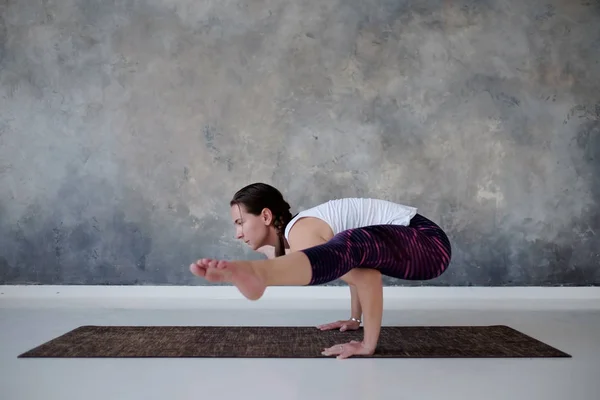 Woman doing handstand, variation of Firefly posture, Tittibhasana. — Stock Photo, Image