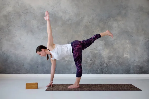 Woman practicing yoga in twisted Half Moon exercise, Ardha Chandrasana pose. — Stock Photo, Image
