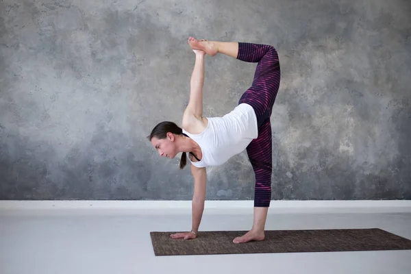 Mujer practicando yoga de pie en medio de la luna ejercicio, Ardha Chandrasana pose — Foto de Stock