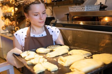 Satıcı fırında taze turta pişirme fırın tepsisi koyar.