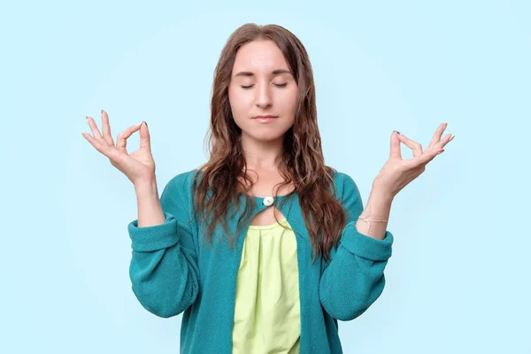 Jonge vrouw mediteren, haar handen in mudra houden, kalm en positief voelen — Stockfoto