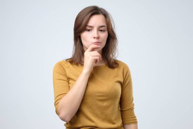 Gözlüklü kadın, dalgın ifadeyle bir kenara bakıyor,