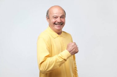 Çok heyecanlı olgun İspanyol adam, yükseltilmiş elleriyle zafer kutluyor