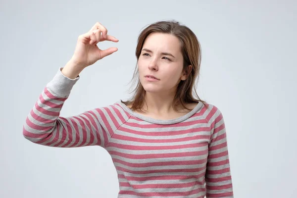 Woman showing something small and tiny with gesture