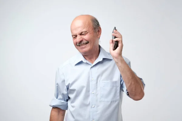 Caucasiano maduro homem é irritado com telefone conversa . — Fotografia de Stock