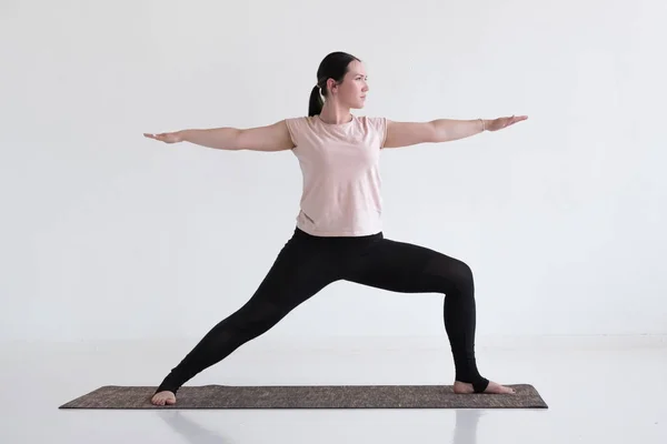 Caucasian woman doing warrior pose two from yoga. — Stock Photo, Image