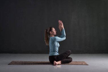 Gomukhasana oturan genç kadın, Cowface poz varyasyon