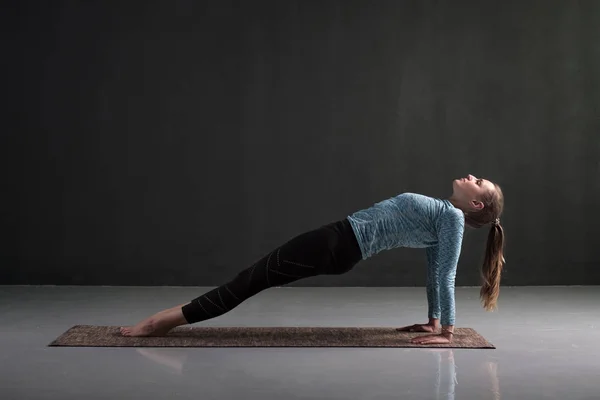 Woman practices yoga asana purvottanasana or upward facing plank — Stock Photo, Image