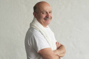 Beyaz havlu ile ayakta tıraş ve gülümseyen sonra Kıdemli hisanik adam.