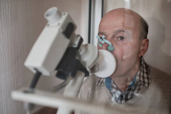 Homem hispânico sênior testando a função respiratória por espirometria — Fotografia de Stock