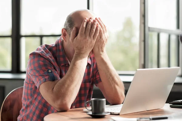 Man rubbing his tired eyes. He is tired to look on laptop screen — Stock Photo, Image